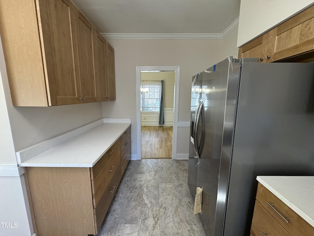 kitchen with light countertops, ornamental molding, brown cabinetry, and stainless steel refrigerator with ice dispenser