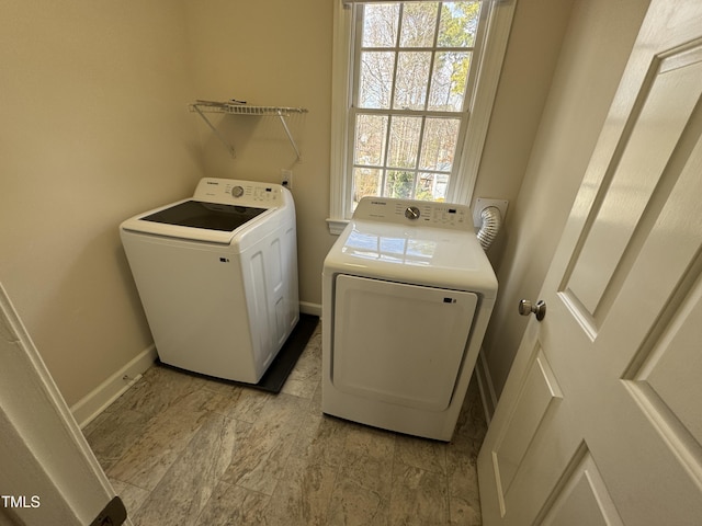 laundry area featuring laundry area, separate washer and dryer, and baseboards