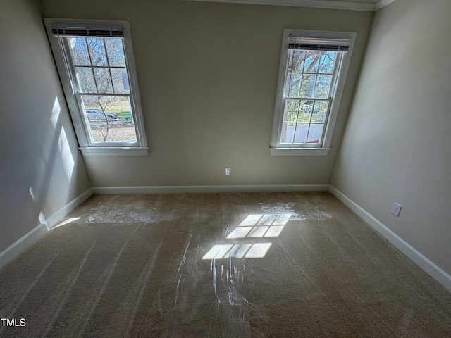 carpeted empty room featuring baseboards