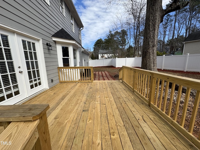 wooden deck with french doors and a fenced backyard