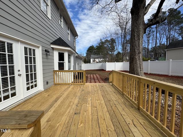 wooden terrace featuring french doors and a fenced backyard