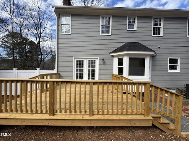 back of house featuring french doors, fence, a chimney, and a wooden deck