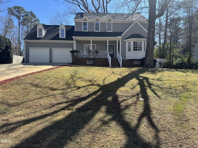 view of front of property featuring covered porch, concrete driveway, a front lawn, and an attached garage