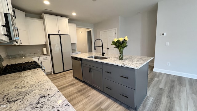 kitchen featuring a sink, white cabinets, range, freestanding refrigerator, and dishwasher