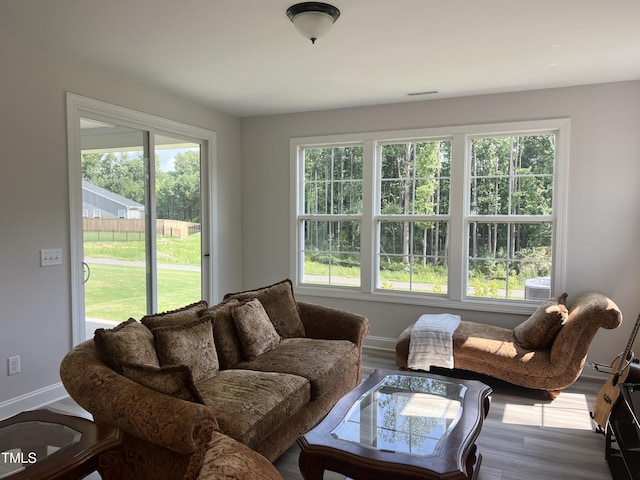 living room with baseboards, visible vents, and light wood finished floors