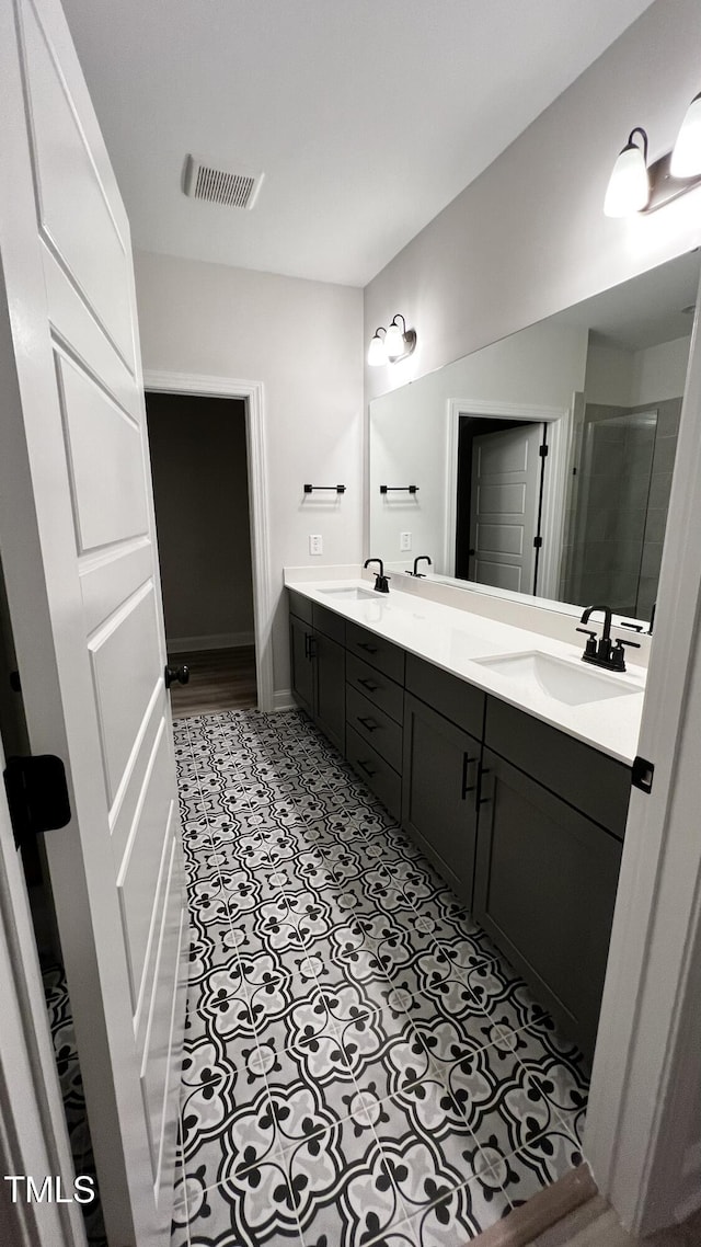 full bath with double vanity, a stall shower, visible vents, and a sink