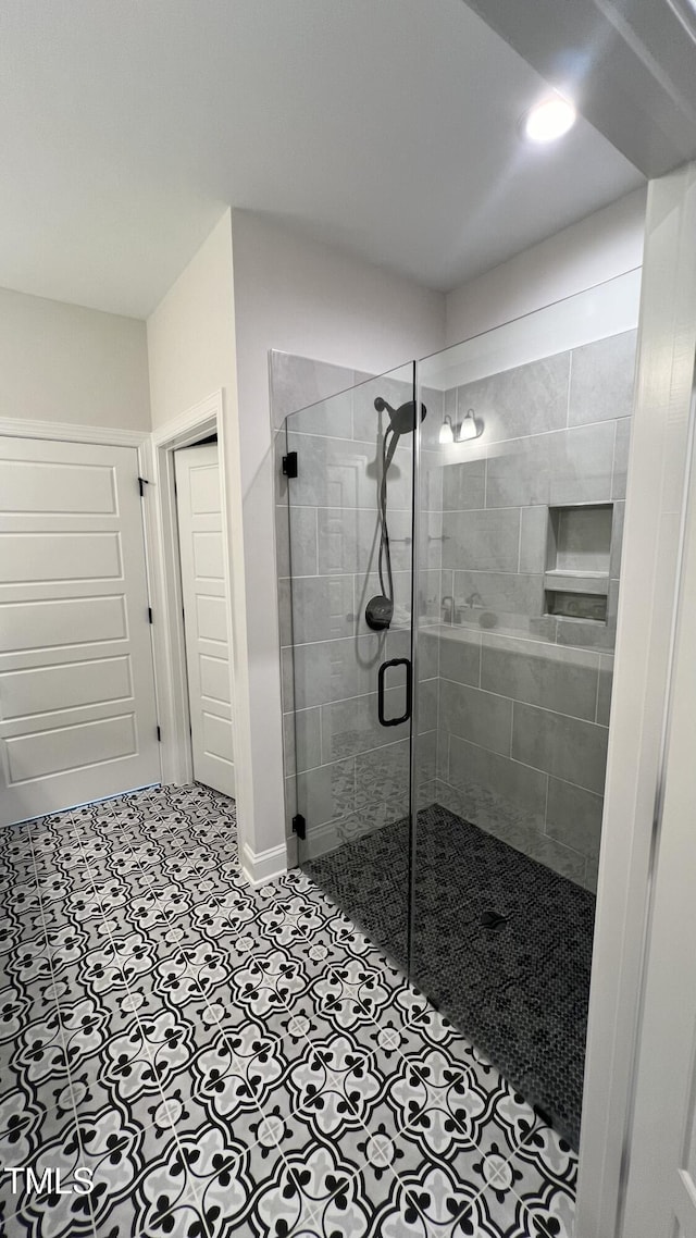 full bathroom featuring a stall shower and tile patterned flooring