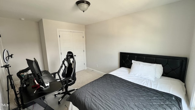 carpeted bedroom featuring baseboards and a closet