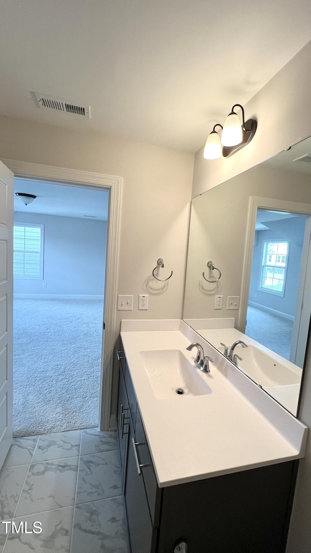 bathroom with marble finish floor, vanity, and visible vents