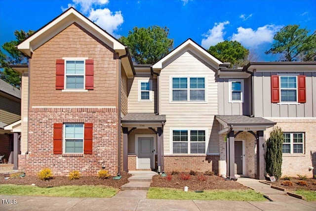 view of front of home featuring board and batten siding and brick siding