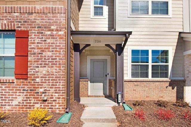 entrance to property featuring brick siding