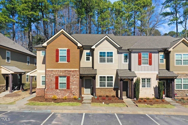 multi unit property with board and batten siding, brick siding, and a shingled roof