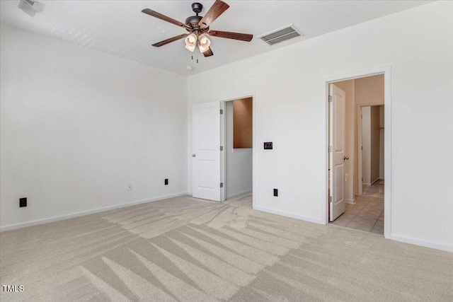 unfurnished bedroom with light carpet, ceiling fan, visible vents, and baseboards