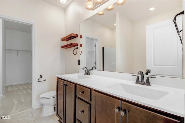 bathroom with a sink, a spacious closet, toilet, and double vanity