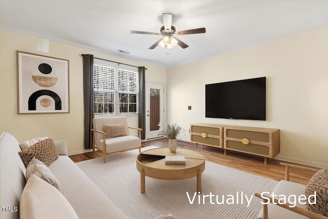 living room with ornamental molding, ceiling fan, and wood finished floors