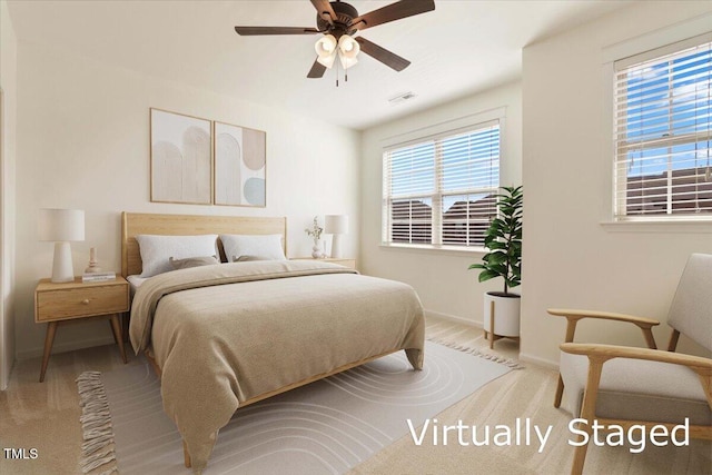 bedroom featuring a ceiling fan, visible vents, light carpet, and baseboards