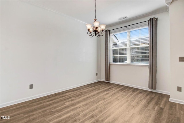 unfurnished room featuring crown molding, visible vents, wood finished floors, a chandelier, and baseboards