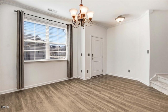 unfurnished dining area with a notable chandelier, wood finished floors, visible vents, baseboards, and ornamental molding