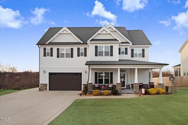 craftsman inspired home with a garage, driveway, a porch, and a front lawn