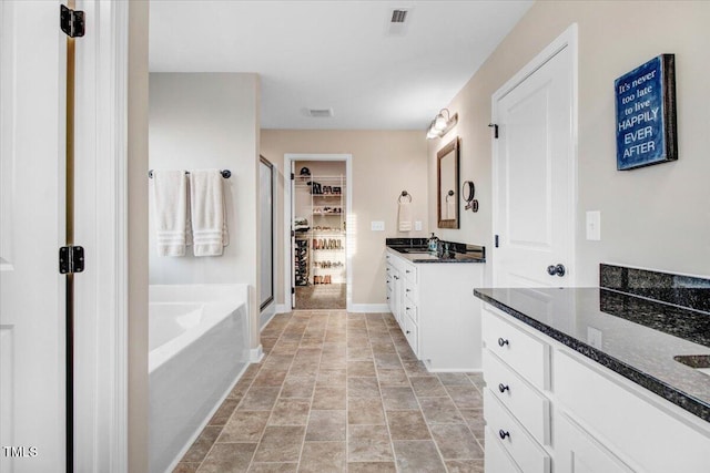 301 Stonebridge Dr, Pikeville, NC 27863 - full bath with two vanities, visible vents, a sink, baseboards, and a bath