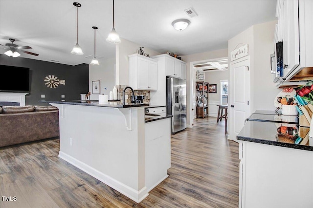 301 Stonebridge Dr, Pikeville, NC 27863 - kitchen featuring visible vents, white cabinetry, open floor plan, hanging light fixtures, and stainless steel fridge