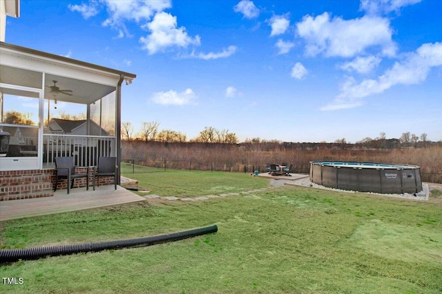 301 Stonebridge Dr, Pikeville, NC 27863 - view of yard featuring a sunroom, an outdoor pool, a ceiling fan, and a wooden deck