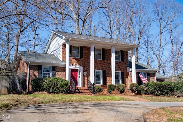 greek revival house featuring brick siding and fence