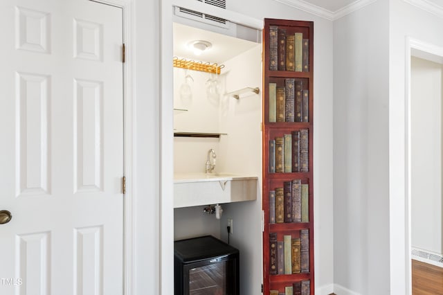 interior space featuring wine cooler, visible vents, and a sink