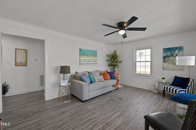 living area featuring baseboards, visible vents, wood finished floors, and a ceiling fan