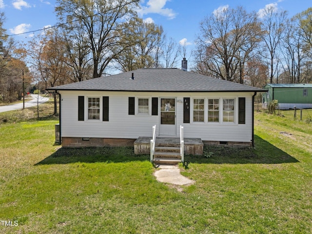 view of front facade with a shingled roof, a chimney, crawl space, and a front yard