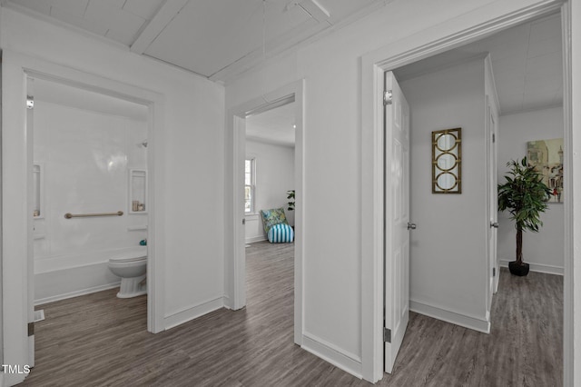 hall with baseboards and wood finished floors
