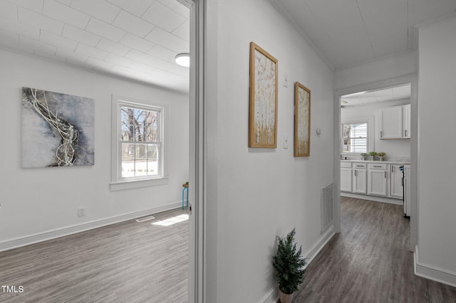 hall featuring baseboards, visible vents, and dark wood-type flooring
