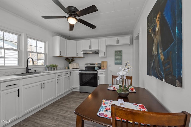 kitchen featuring a sink, stainless steel range with electric stovetop, under cabinet range hood, ceiling fan, and dark wood-style flooring