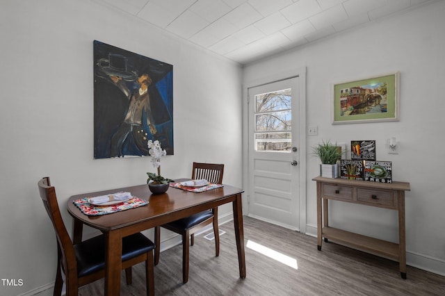 dining room with baseboards, crown molding, and wood finished floors