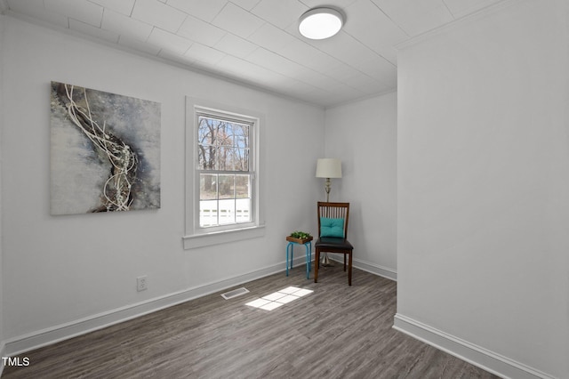 unfurnished room featuring dark wood finished floors, baseboards, and visible vents