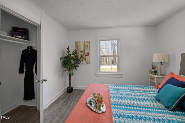 bedroom with crown molding, baseboards, and wood finished floors