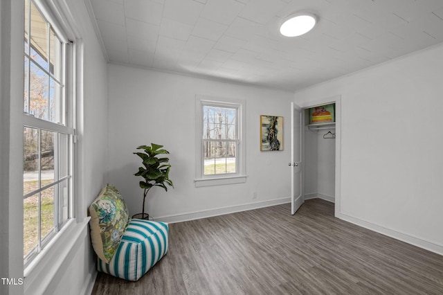 sitting room featuring plenty of natural light, baseboards, and wood finished floors