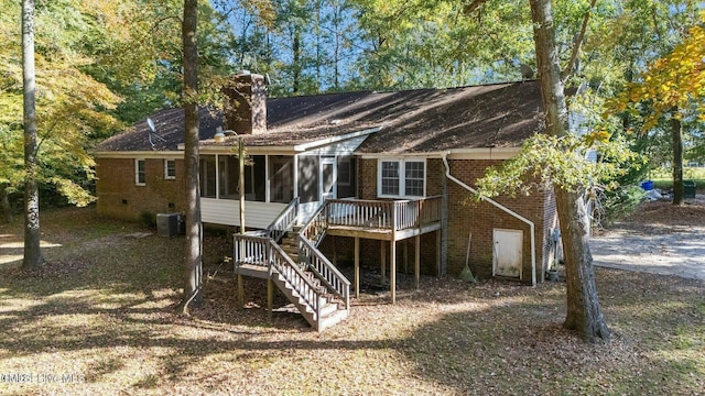 rear view of house with a sunroom, stairway, a deck, central air condition unit, and brick siding