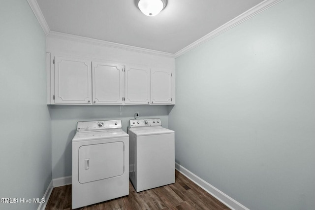 laundry area featuring dark wood-style flooring, washing machine and clothes dryer, cabinet space, ornamental molding, and baseboards