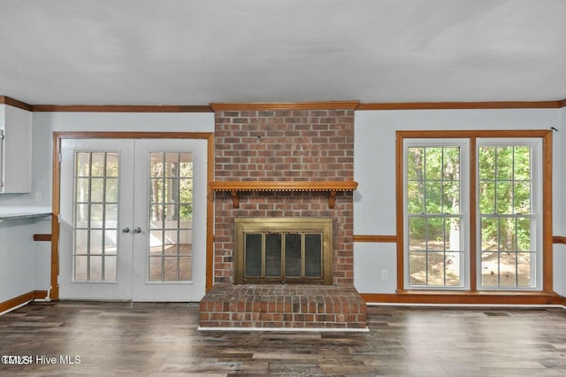 unfurnished living room with a fireplace, ornamental molding, and dark wood finished floors