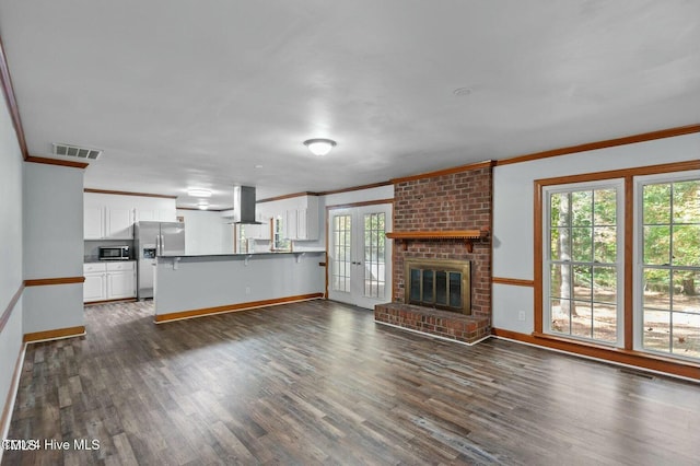 unfurnished living room with ornamental molding, dark wood-style flooring, visible vents, and french doors