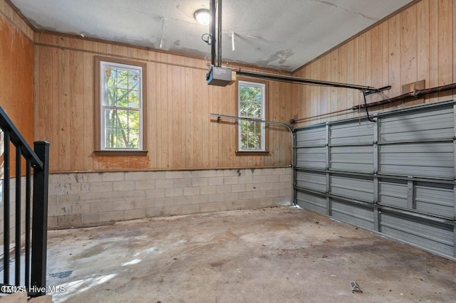 garage with a garage door opener and concrete block wall