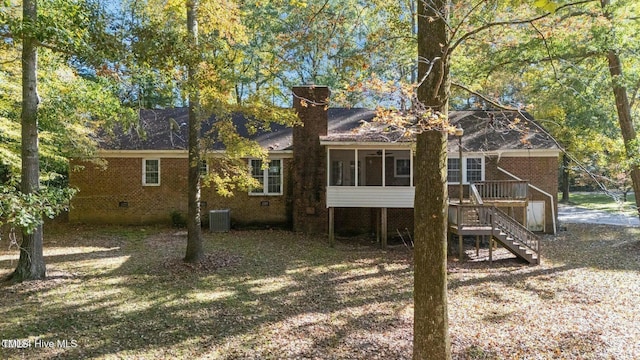 back of property featuring brick siding, a sunroom, central AC, a deck, and stairs