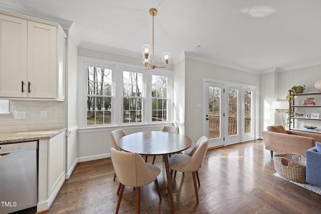 dining room featuring dark wood-style floors, baseboards, ornamental molding, and an inviting chandelier