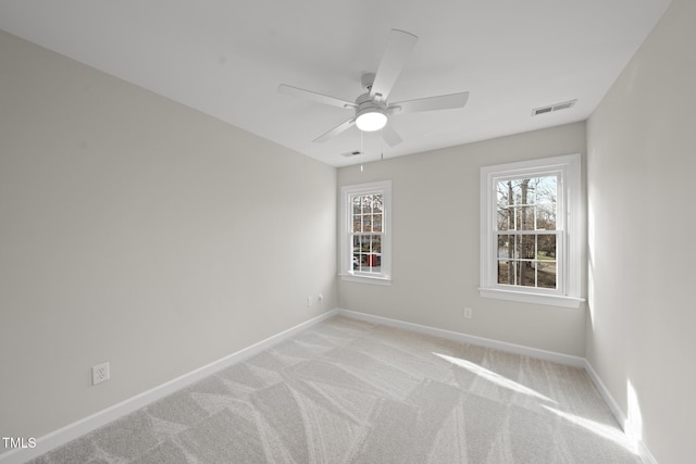 empty room with a healthy amount of sunlight, visible vents, and baseboards