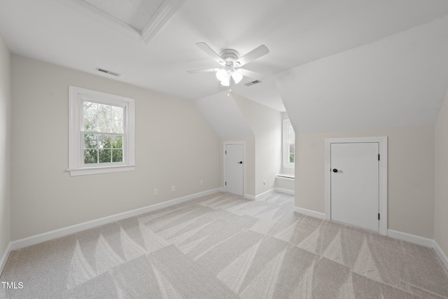 additional living space featuring visible vents, vaulted ceiling, and light colored carpet