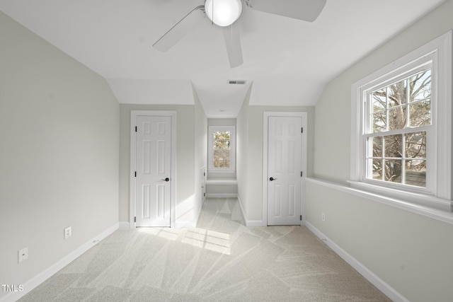 unfurnished bedroom with carpet floors, visible vents, vaulted ceiling, and baseboards