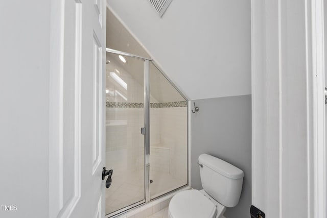 bathroom featuring a stall shower, visible vents, vaulted ceiling, and toilet