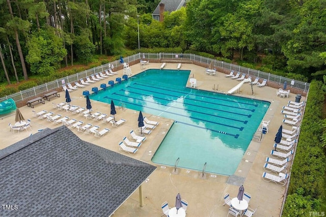 pool with a patio and fence