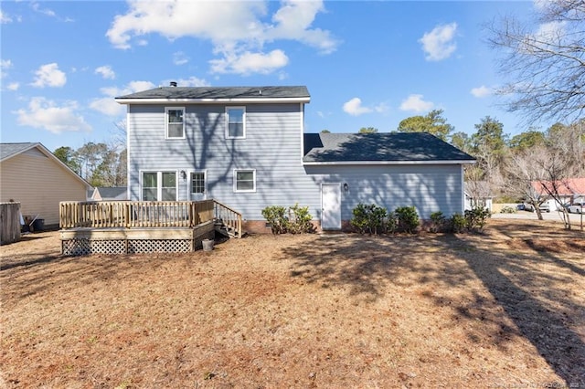 back of property featuring a yard and a wooden deck